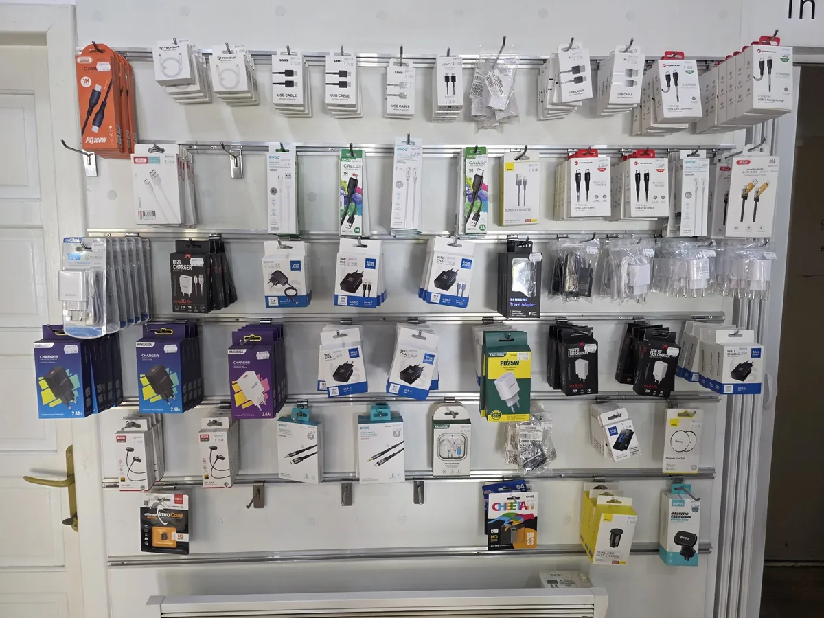 Peretele cu încărcătoare, cabluri și căști din magazinul MobilX